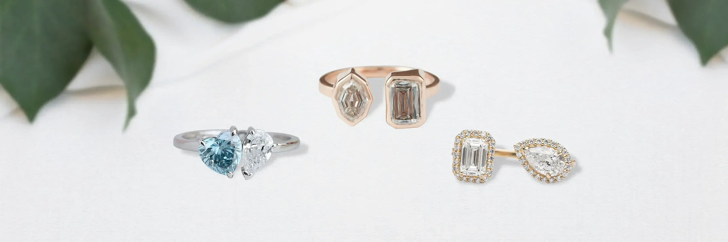 Three lab-grown diamond Toi et Moi engagement rings in yellow gold — open split shank with pear and round cut, double oval cluster solitaire, and asymmetric three-stone with round diamonds and pavé band