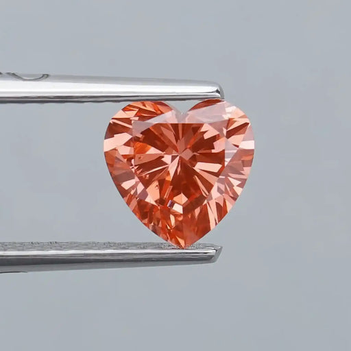 0.90ct vivid pink heart shaped lab grown diamond loose held with tweezer