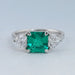 front view of green asscher gemstone with heart lab diamond three stone engagement ring