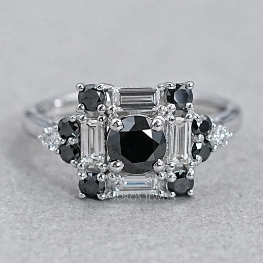 top view of black round diamond baguette halo engagement ring on grey fabric