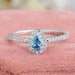 front view of blue pear-cut lab diamond halo colored engagement ring