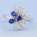 front view of blue sapphire oval cut gemstone cluster engagement ring