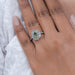 green pear cut surround double halo diamond engagement ring in finger