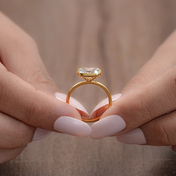 close-up east west cushion cut diamond bezel solitaire engagement ring