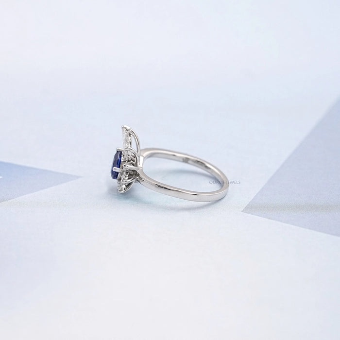 left view of pear cut blue sapphire gemstone cluster bypass engagement ring