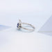 left view of pear cut blue sapphire gemstone cluster bypass engagement ring