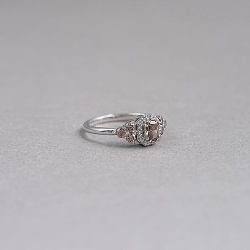 right side view of brown cushion cut diamond halo wedding ring on grey fabric