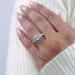 emerald cut diamond five stone engagement ring with white gold band on model's finger