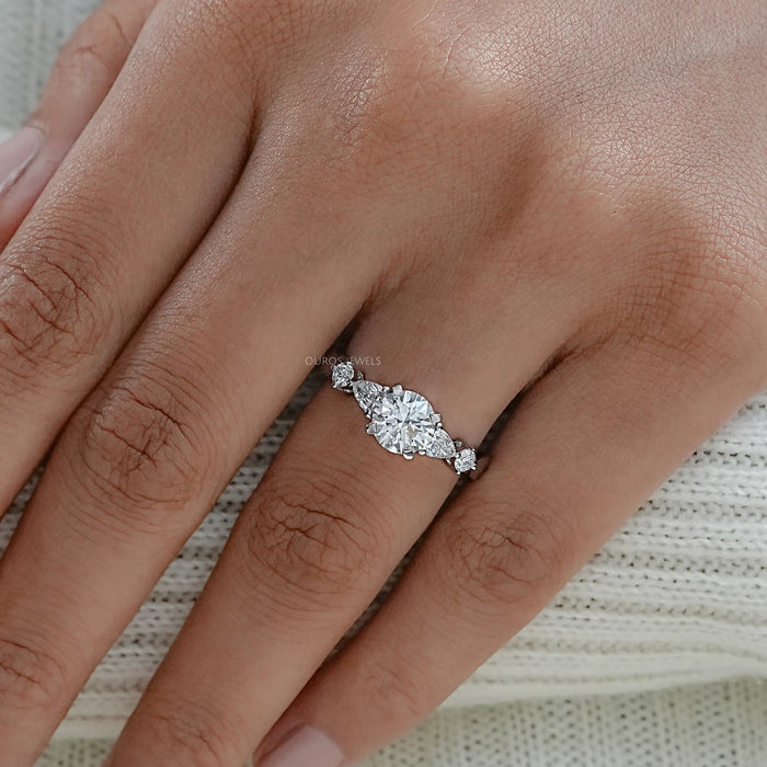 round and pear cut lab diamond five stone engagement ring in finger