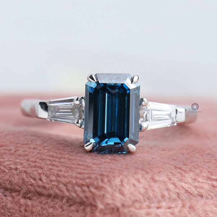front view of blue emerald cut lab diamond three stone engagement ring