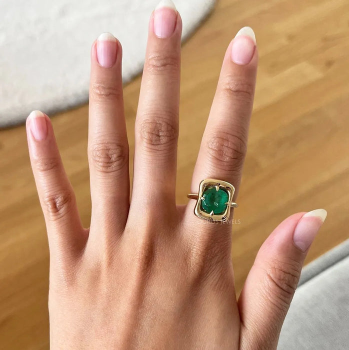 cushion-cut gemstone emerald-shaped band solitaire engagement ring on model's finger
