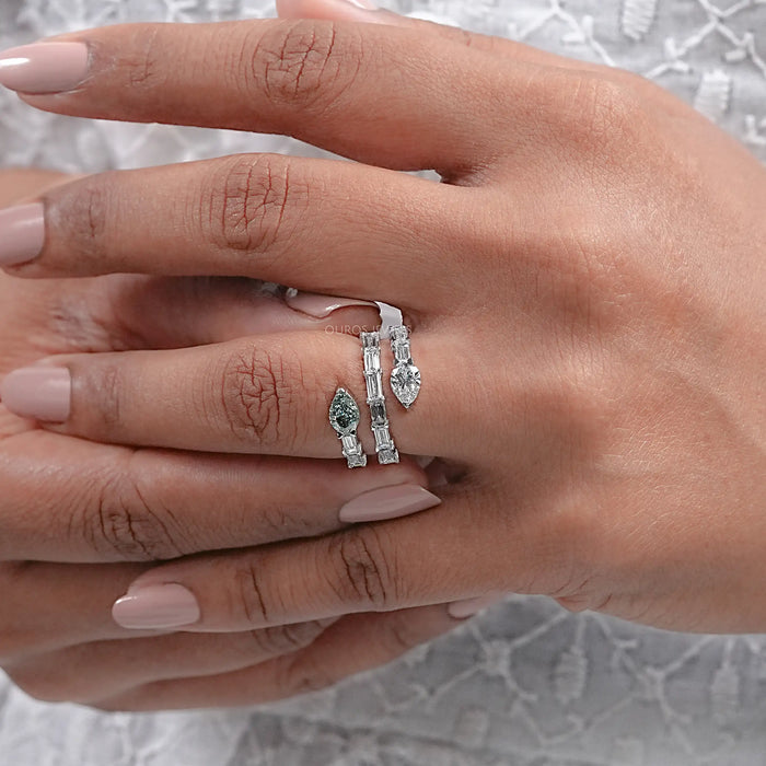 close view of baguette and pear cut diamond spiral colored engagement ring in finger