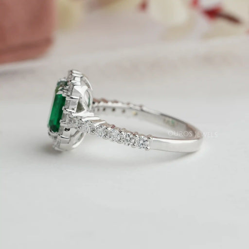 side view of green emerald cut diamond engagement ring halo white gold