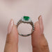 close view of green emerald cut halo diamond engagement ring white gold