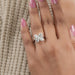 olive pear cut diamond floral halo engagement ring in model's finger