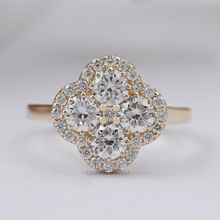 top view of round lab diamond flower halo anniversary ring on grey fabric
