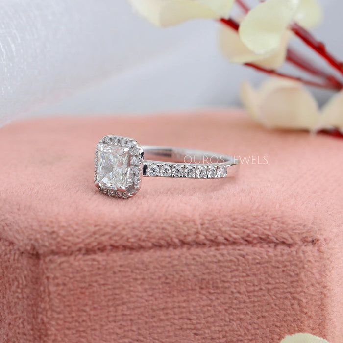 side view of radiant cut diamond solitaire halo wedding band on jewelry box