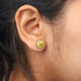 yellow cushion cut halo diamond stud earrings on ear