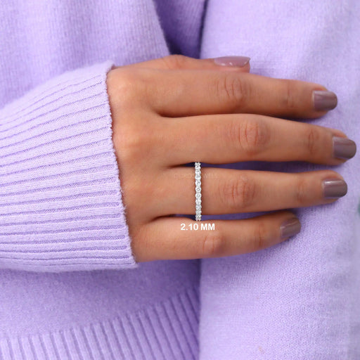 Round Cut Lab Diamond Eternity Wedding Band on a woman's finger, showcasing the elegant design with a 2.10 mm width against a lavender sweater background.