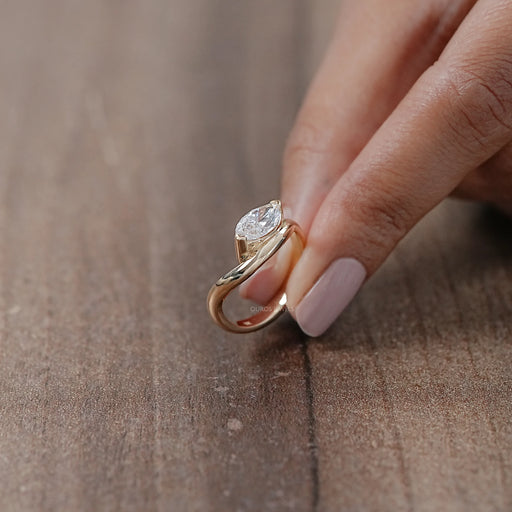 side view of marquise cut lab diamond wave engagement ring in yellow gold