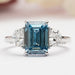 front view of blue emerald with half moon cut diamond three stone engagement ring