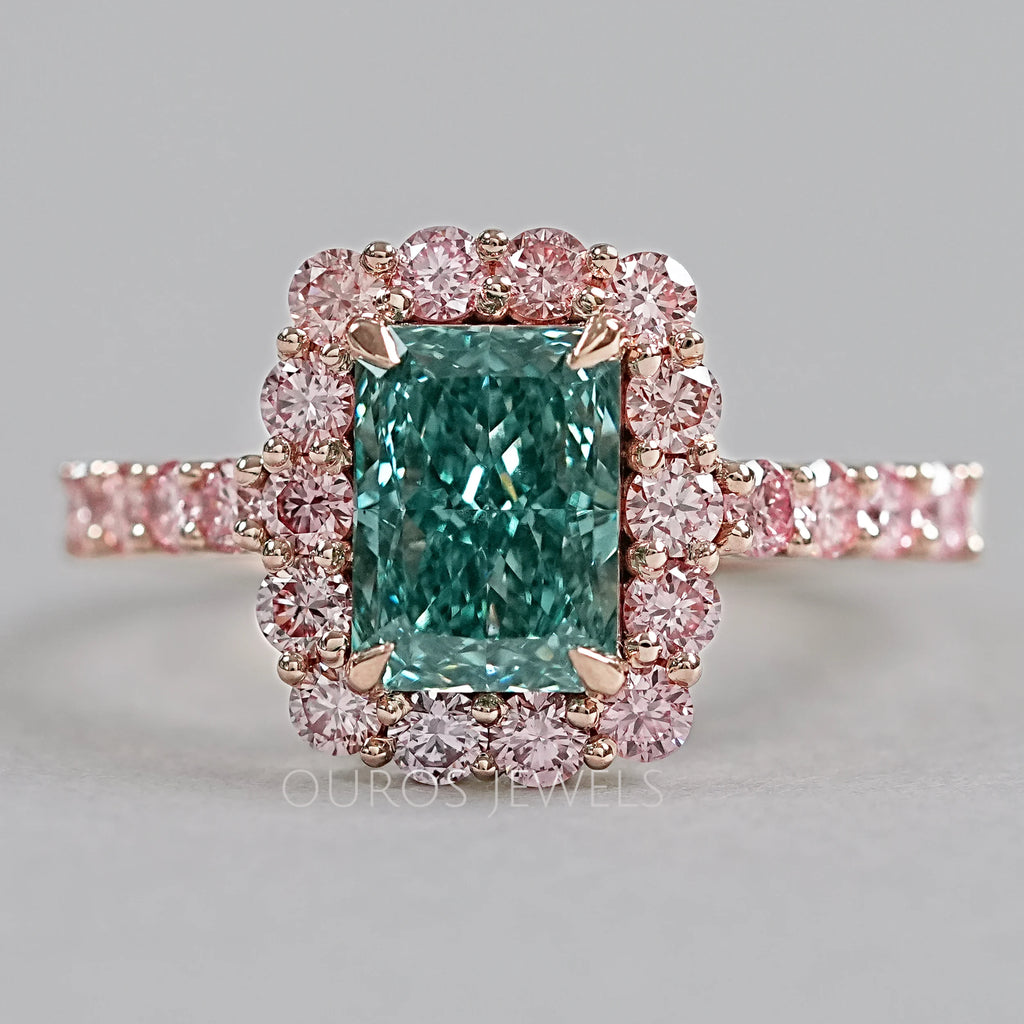 top view of green radiant cut diamond with pink diamond halo engagement ring