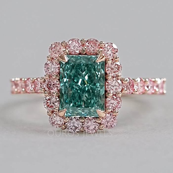top view of green radiant cut diamond with pink diamond halo engagement ring