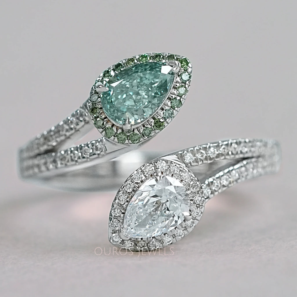 front view of fancy vivid green pear cut diamond bypass halo ring on grey fabric