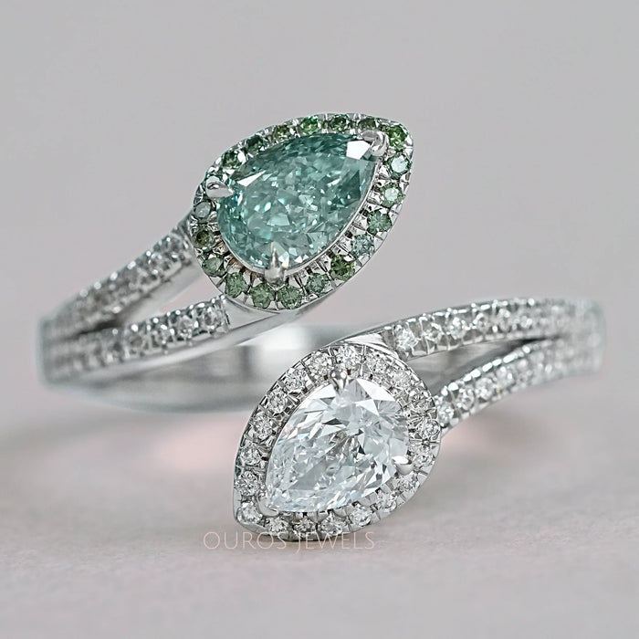 front view of fancy vivid green pear cut diamond bypass halo ring on grey fabric