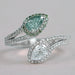 front view of fancy vivid green pear cut diamond bypass halo ring on grey fabric