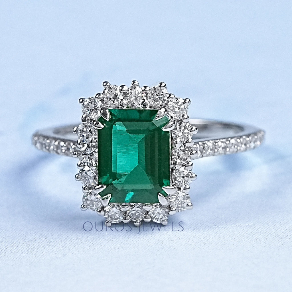 green emerald gemstone with round diamond halo wedding ring's front view