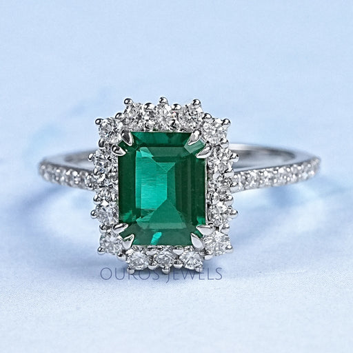 green emerald gemstone with round diamond halo wedding ring's front view