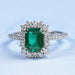green emerald gemstone with round diamond halo wedding ring's front view