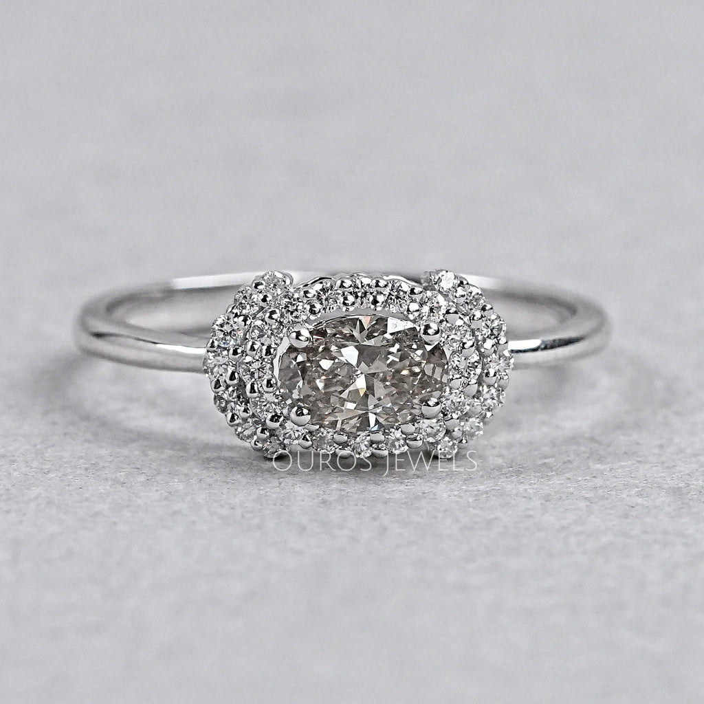 oval diamond halo engagement ring with olive center stone view on grey background
