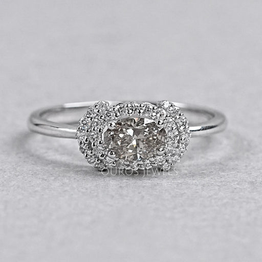 oval diamond halo engagement ring with olive center stone view on grey background