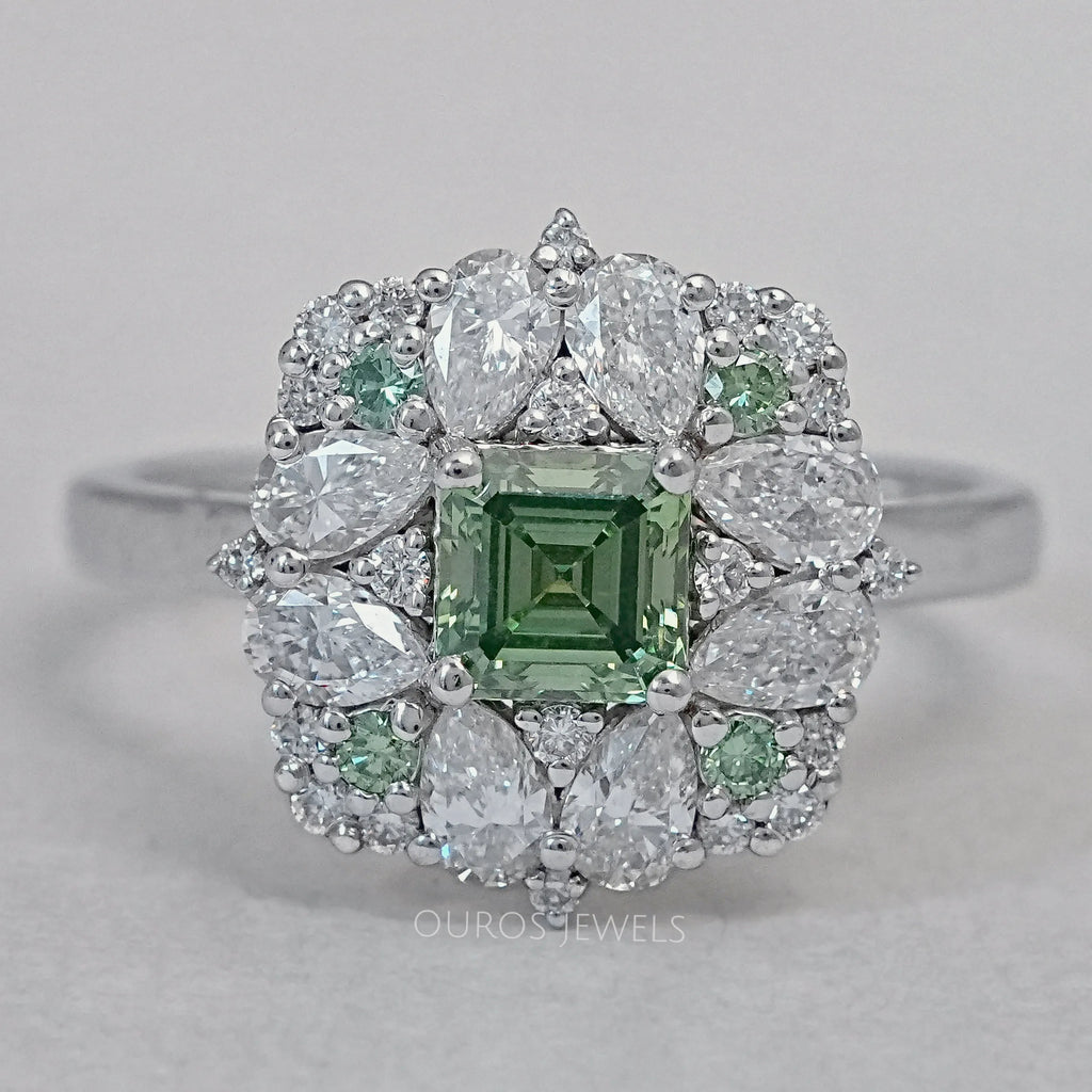 asscher cut green diamond cluster engagement ring's front view on grey fabric