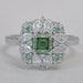 asscher cut green diamond cluster engagement ring's front view on grey fabric