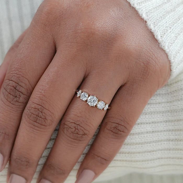 round and marquise cut lab diamond five stone engagement ring on model's finger