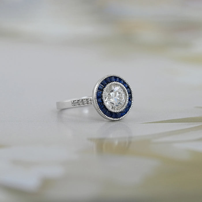 OEC round diamond surround with sapphire baguette halo wedding ring's side view
