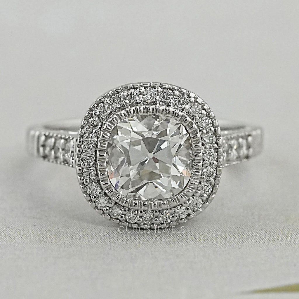 old mine cushion diamond halo engagement ring's front view on grey background