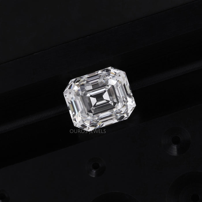 old mine emerald cut loose diamond on the dark blue and black surface 