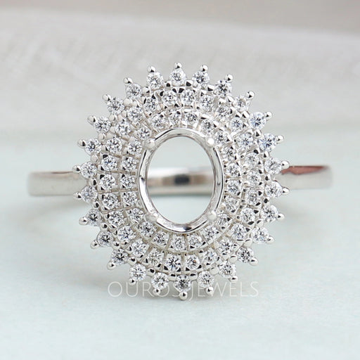 front view of oval-cut semi-mount cluster diamond engagement ring on fabric