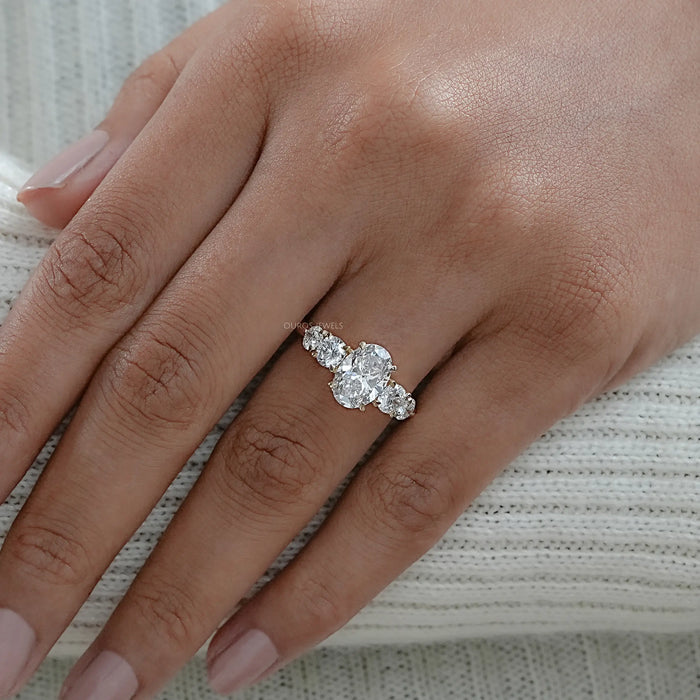 oval and round cut lab diamond five stone engagement ring in finger