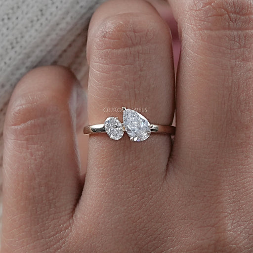 front view of oval and pear cut lab diamond toi et moi engagement ring in finger