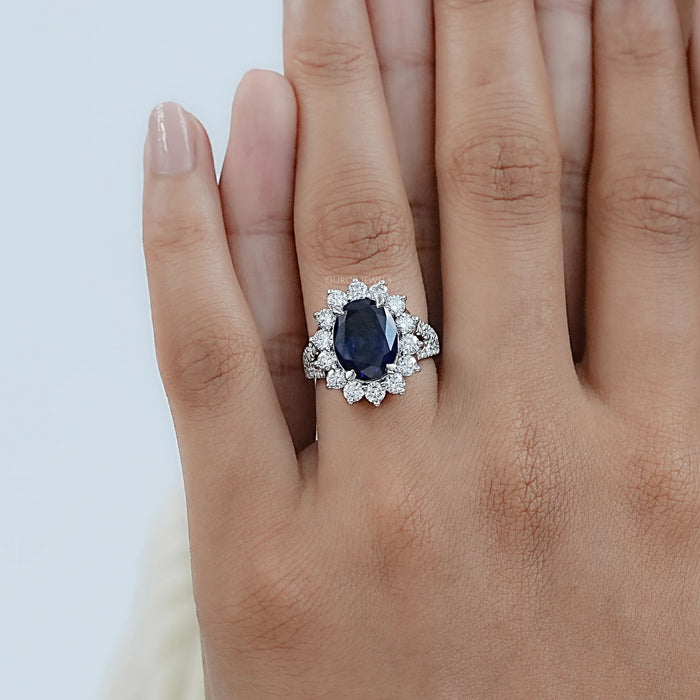 sapphire oval cut gemstone halo split shank engagement ring in finger