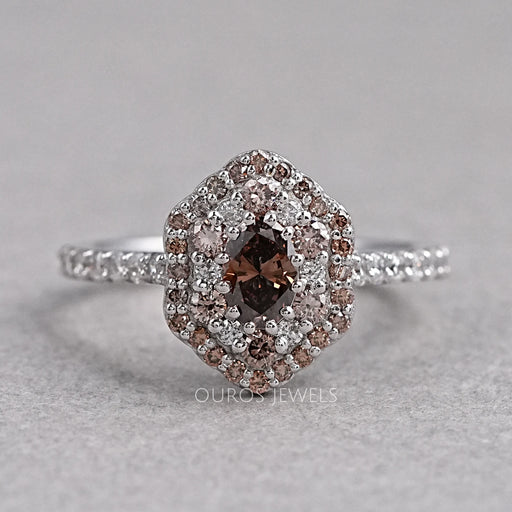 top view of oval cut brown diamond double halo engagement ring on grey fabric