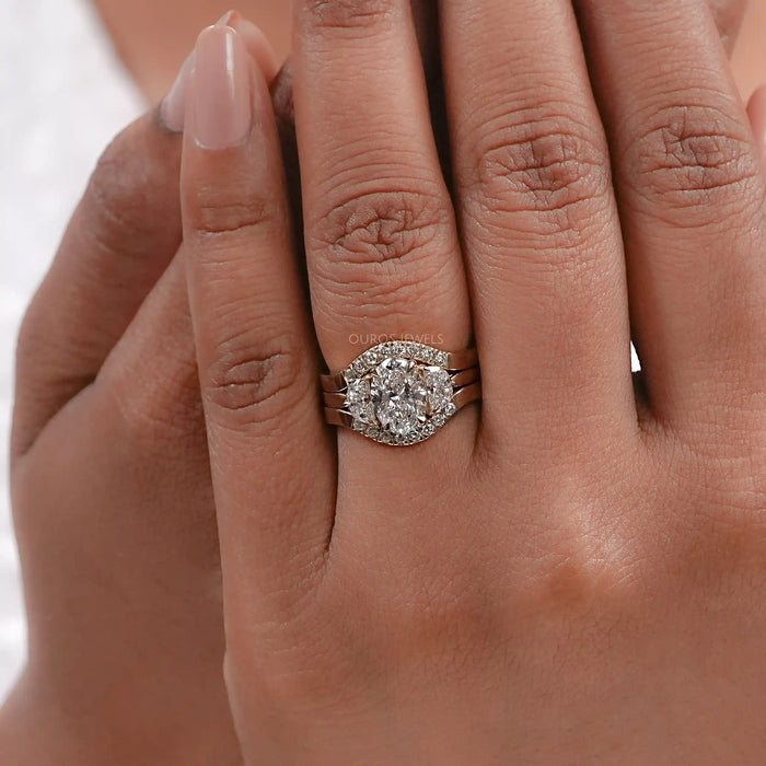 oval-cut lab diamond solitaire bridal ring set with yellow gold band on model's finger