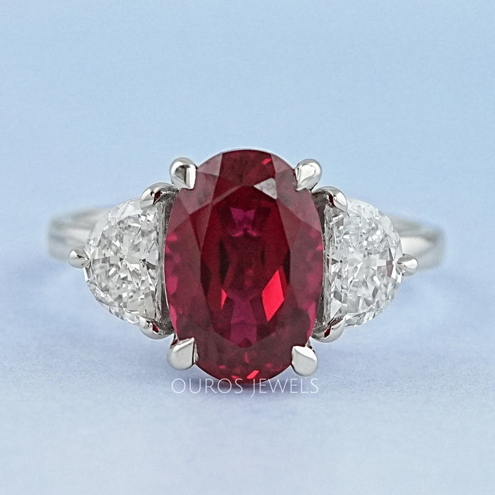 front view of oval ruby gemstone and half moon diamond 3 stone engagement ring