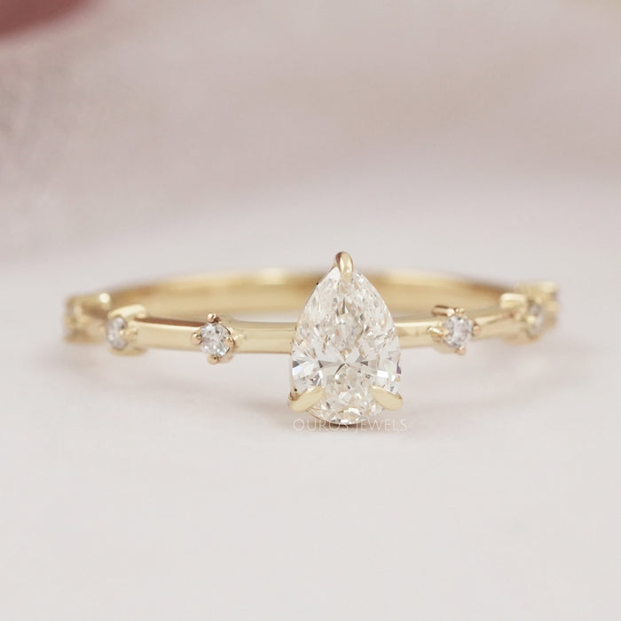 front view of pear-cut diamond solitaire accent wedding ring with yellow gold band