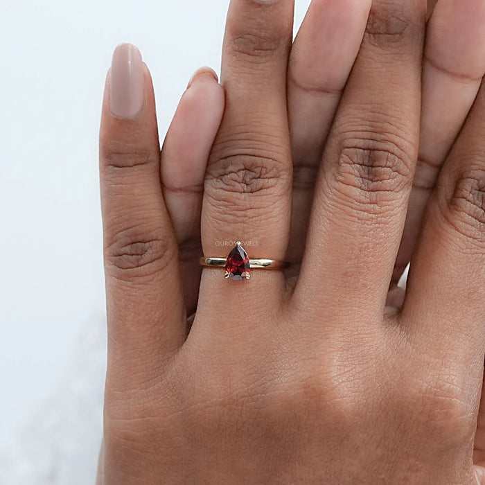garnet pear-cut gemstone engagement ring on model's finger